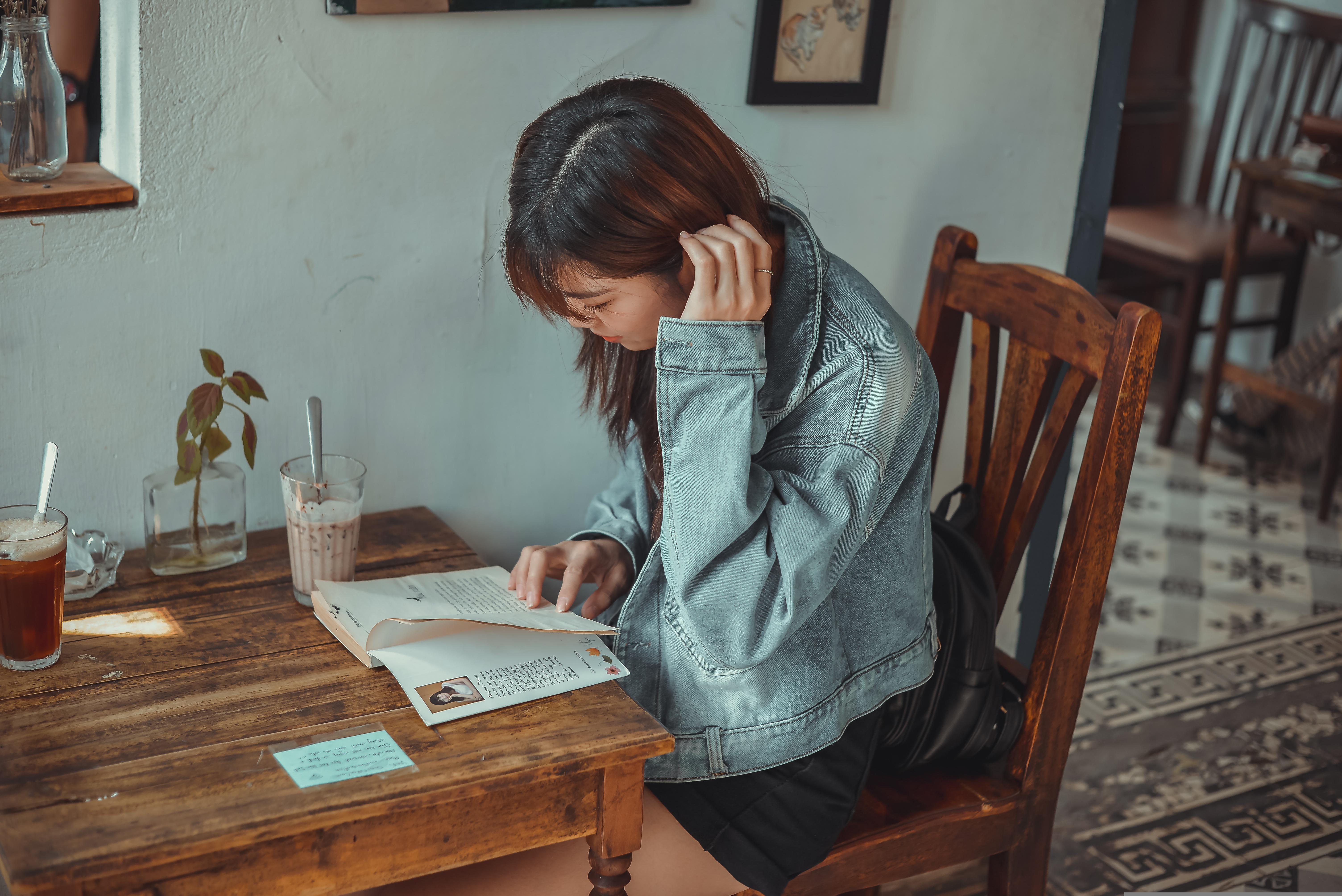 A guest reading at Mocha & Miso — warm wooden table, natural afternoon light